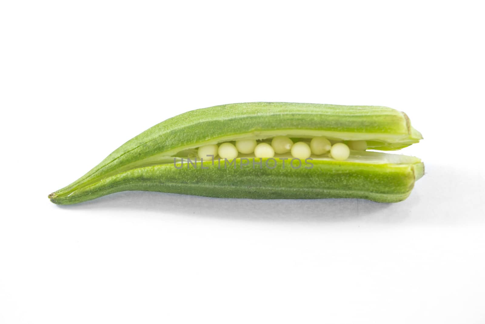 Pile of fresh green okra on white background.