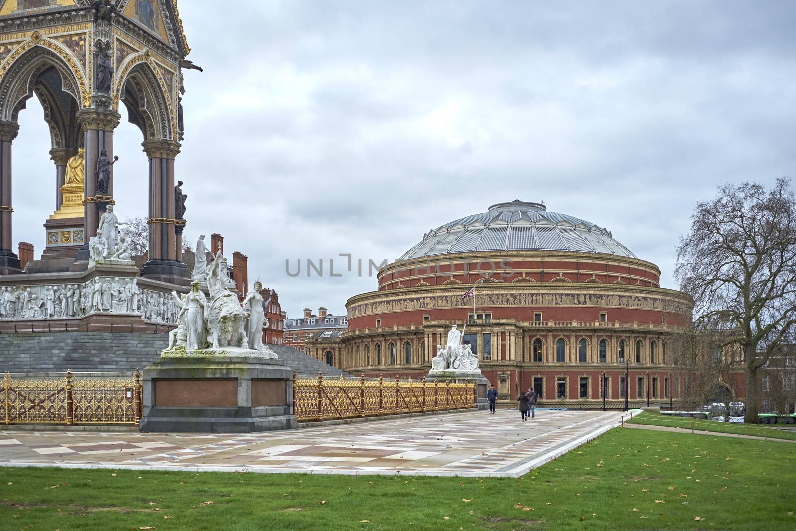 LONDON, UK - DECEMBER 17: People walking past Albert Memorial statues with Royal Albert Hall in the background, in Kensington Gardens. December 17, 2014 in London.