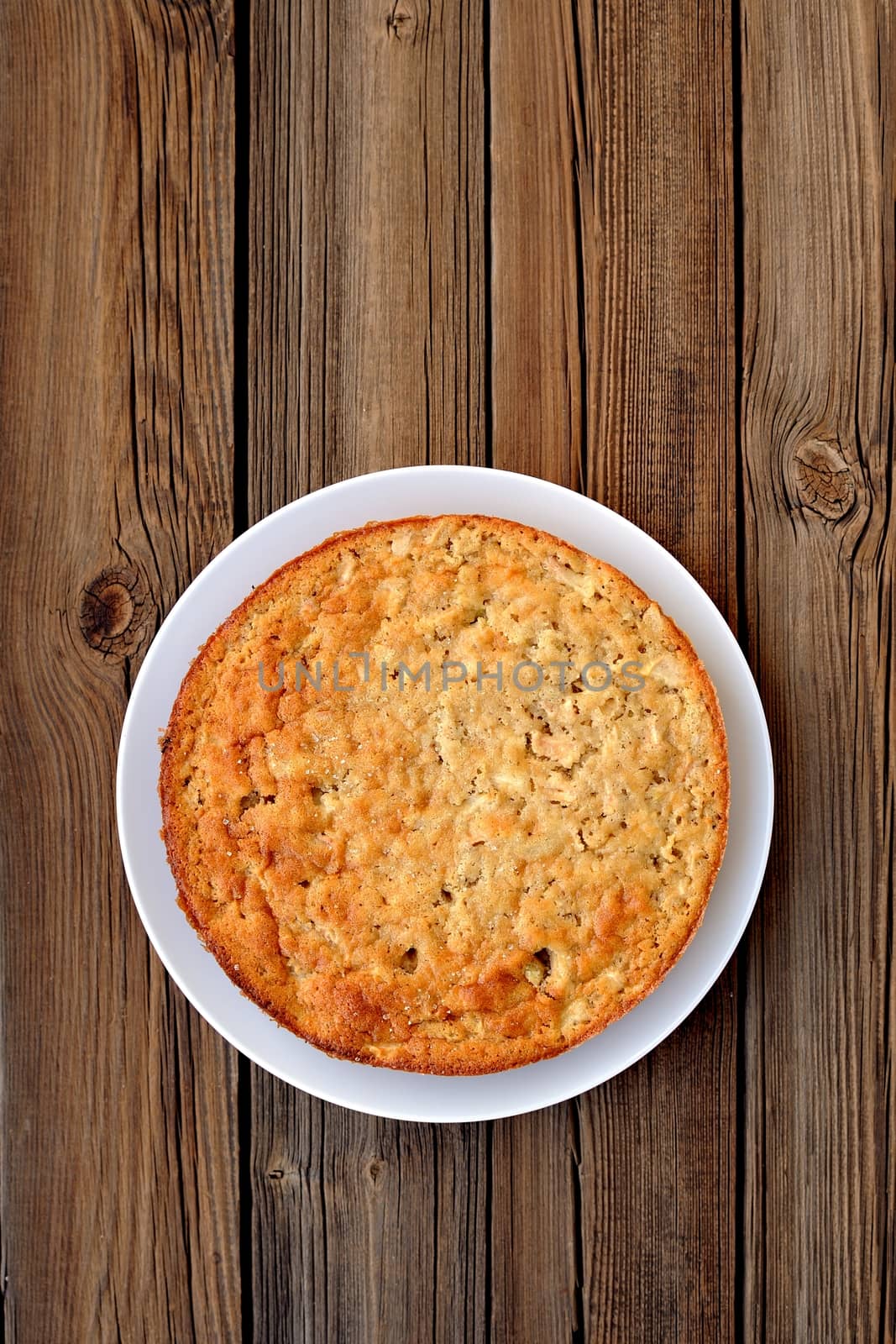 Old-fashioned apple pie on a wooden background vertical