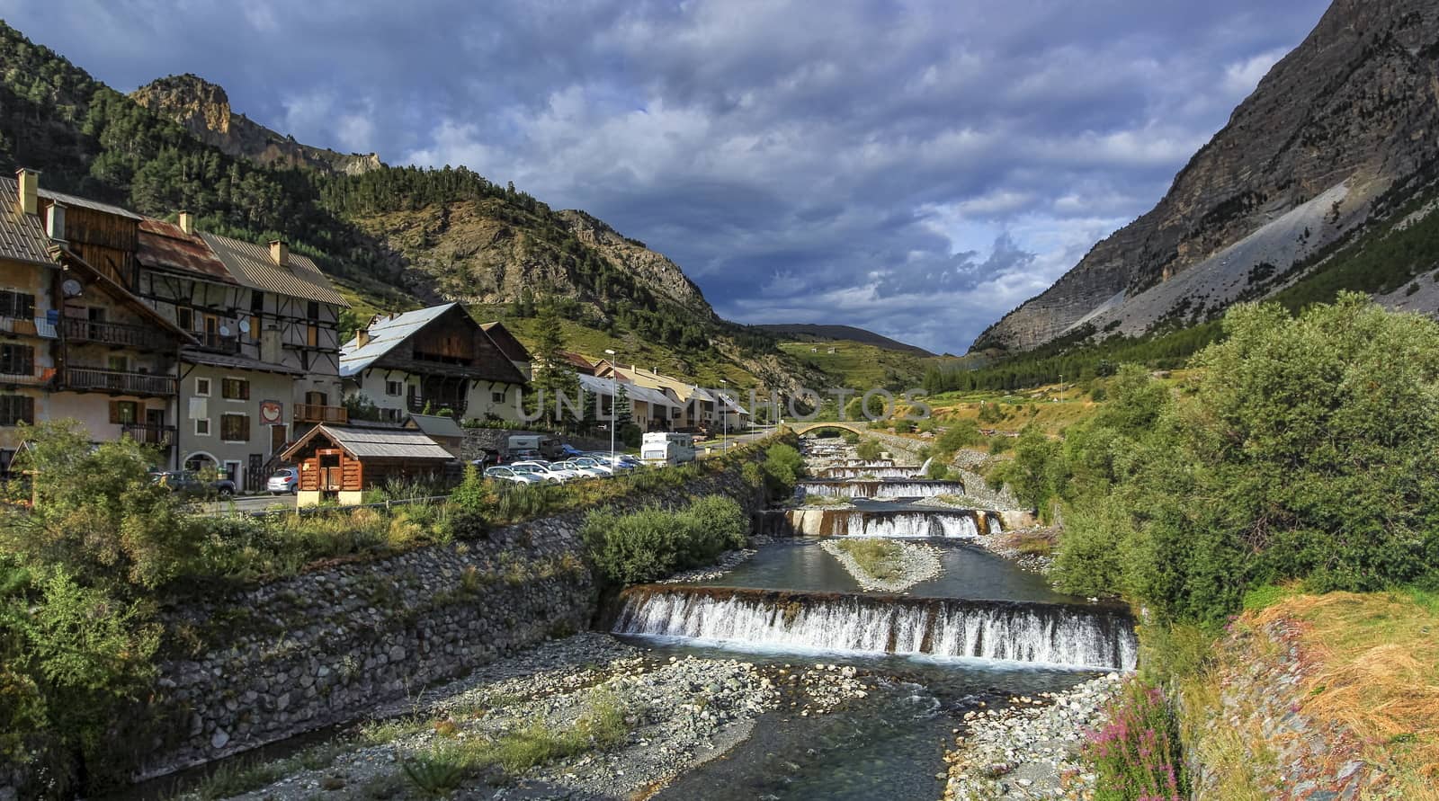 River fall at Cervieres village, Alps mountains, France by Elenaphotos21