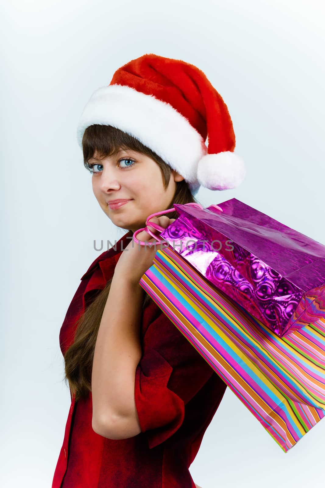 young woman in santa hat with holiday shopping by pzRomashka