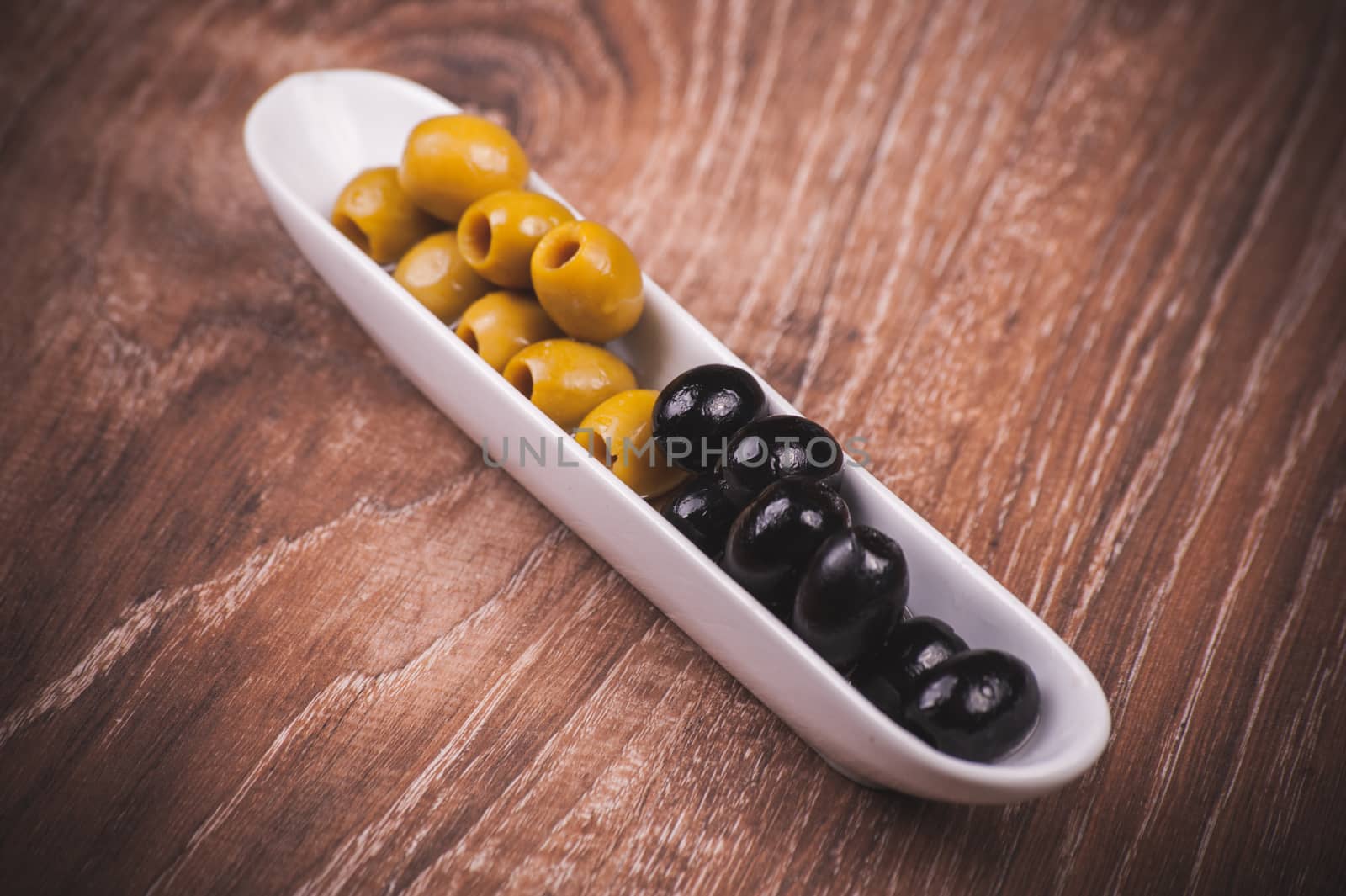 green and black olives without bone in white plate