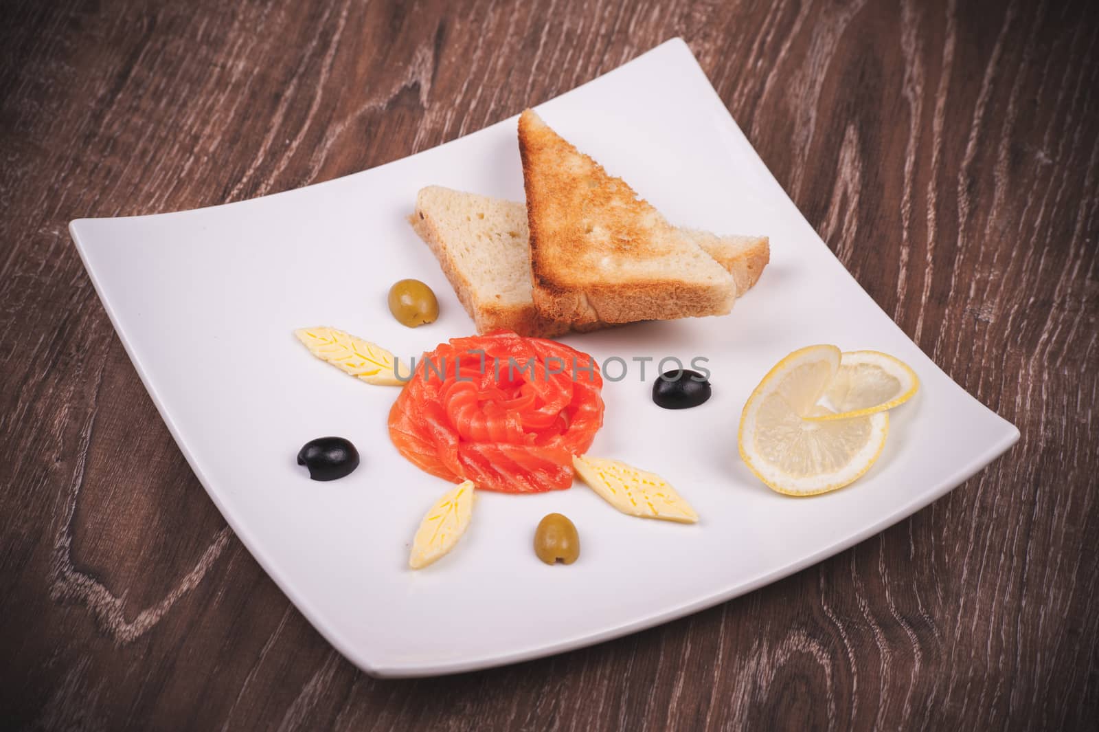 smoked salmon and toasts served on white plate 