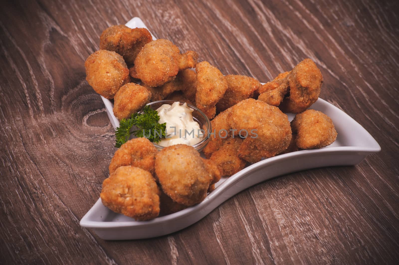 deep fried mushrooms with garlic sauce on white plate