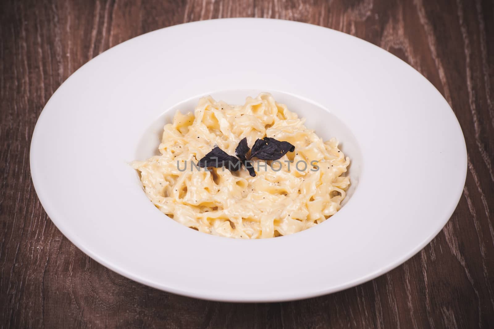 cream sauce pasta served in white plate 