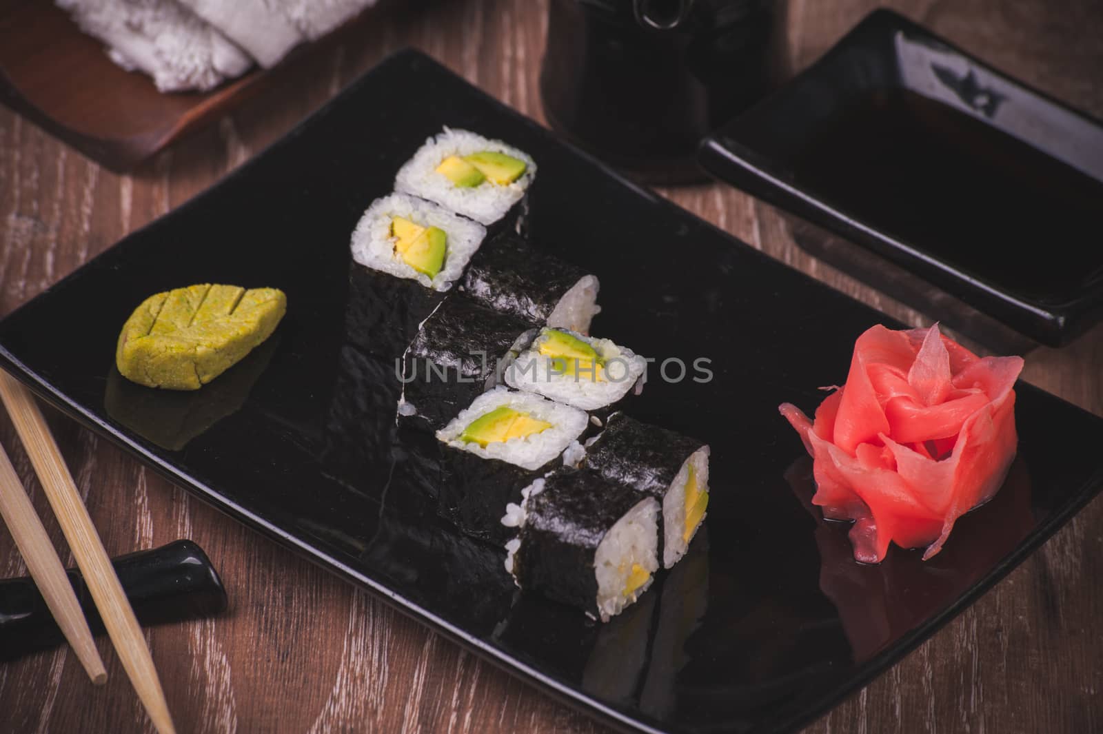 vegetarian avocado sushi roll served on black plate 