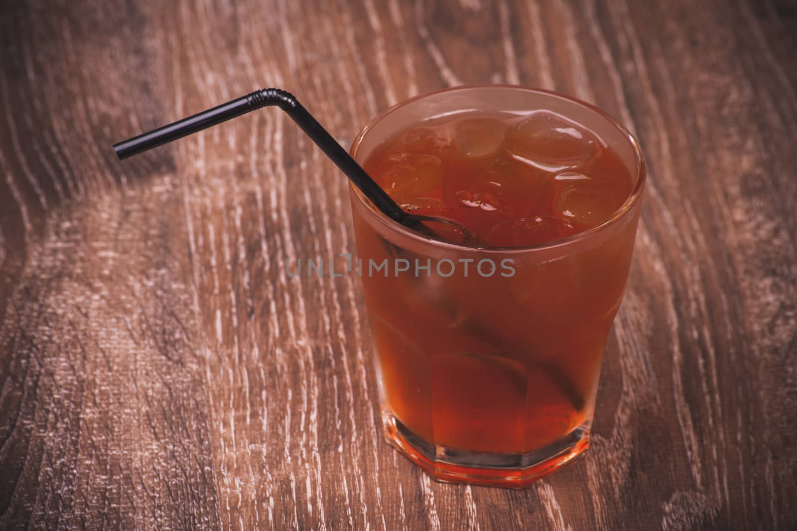 cold ice tea in glass with straw 