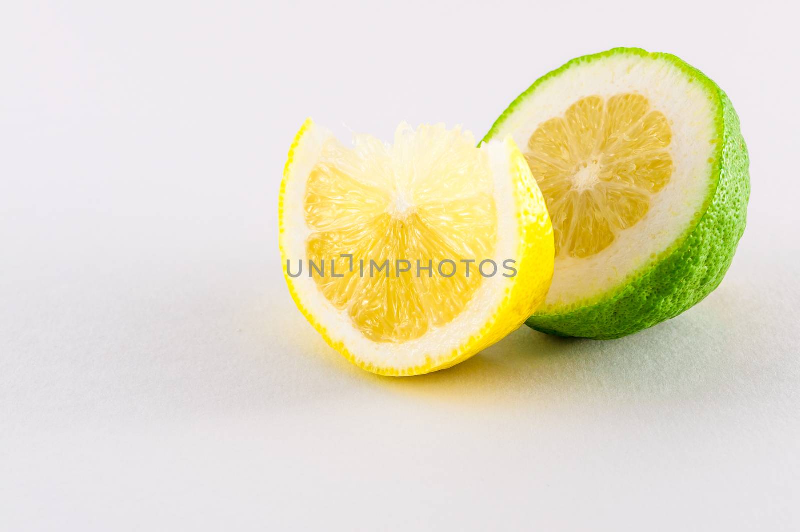 Slice of fresh lemons yellow and green on white background