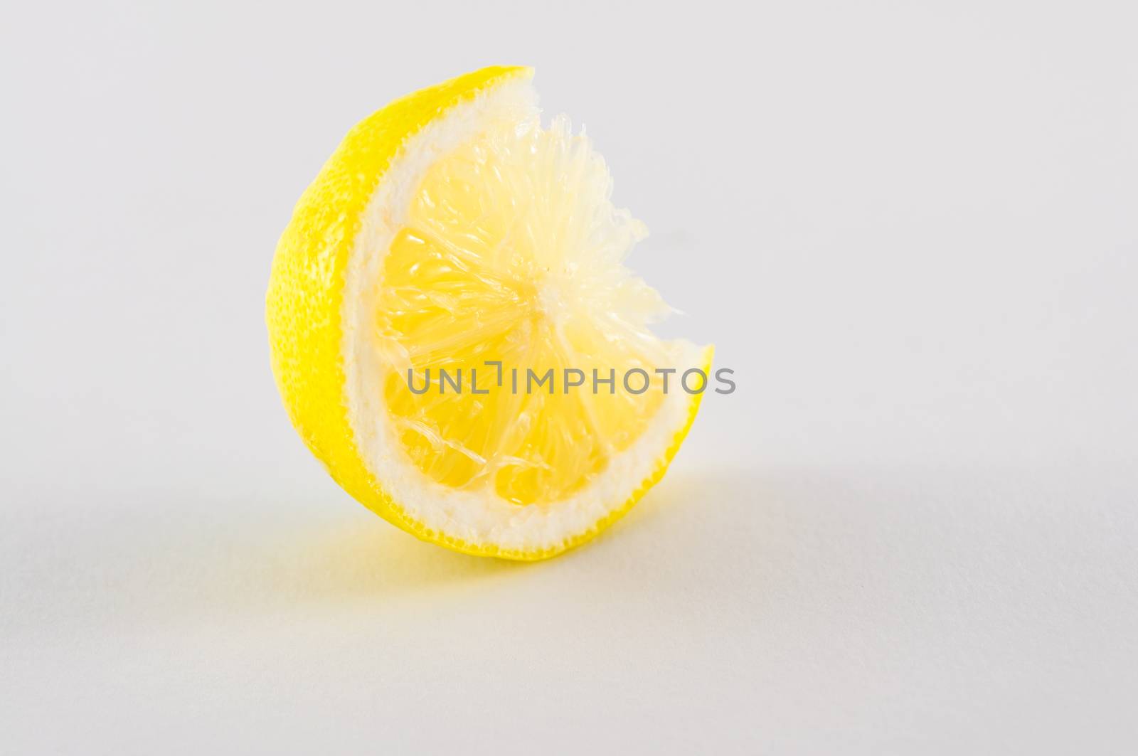 Slice of fresh lemon yellow on white background