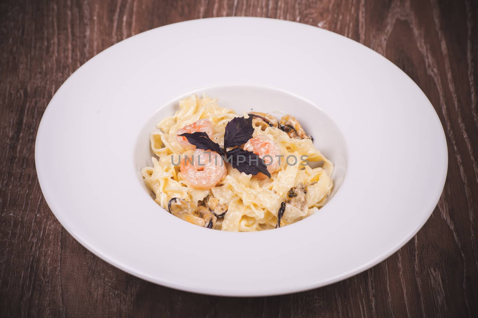 Seafood pasta with creamy sauce on white plate 