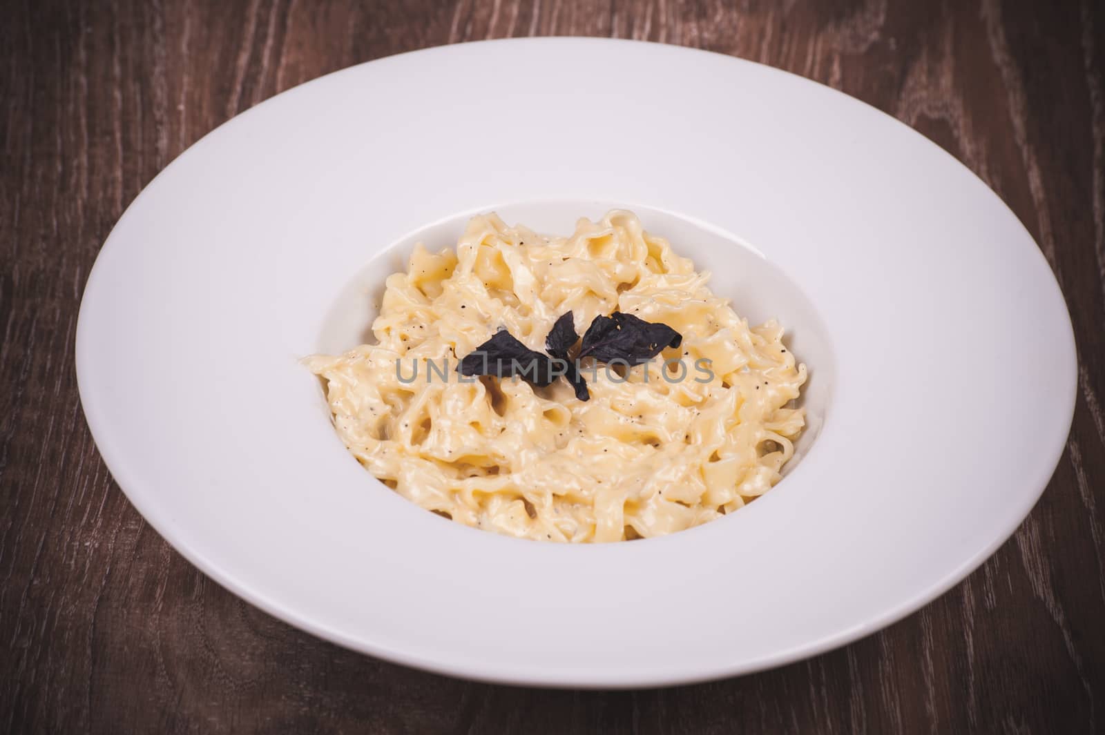 fresh italian pasta carbonara on white plate 