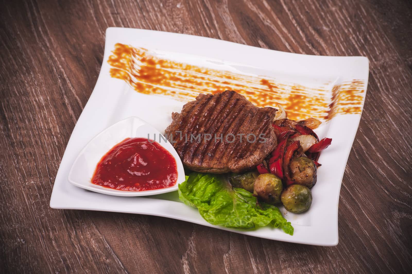 Grilled fillet of beef with vegetables on white plate 