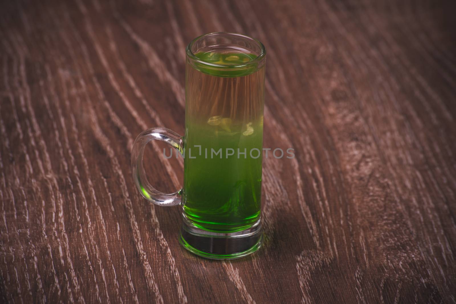 green layered alcohol shot cocktail on wooden background