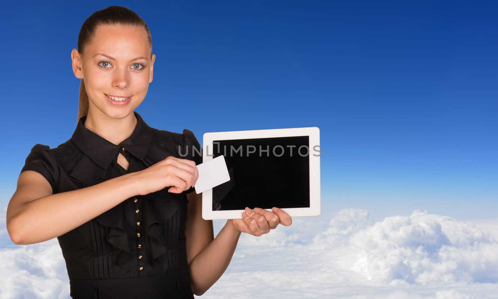 Beautiful businesswoman holding tablet PC and business card in front of screen. Blue sky with cloud layer as backdrop by cherezoff