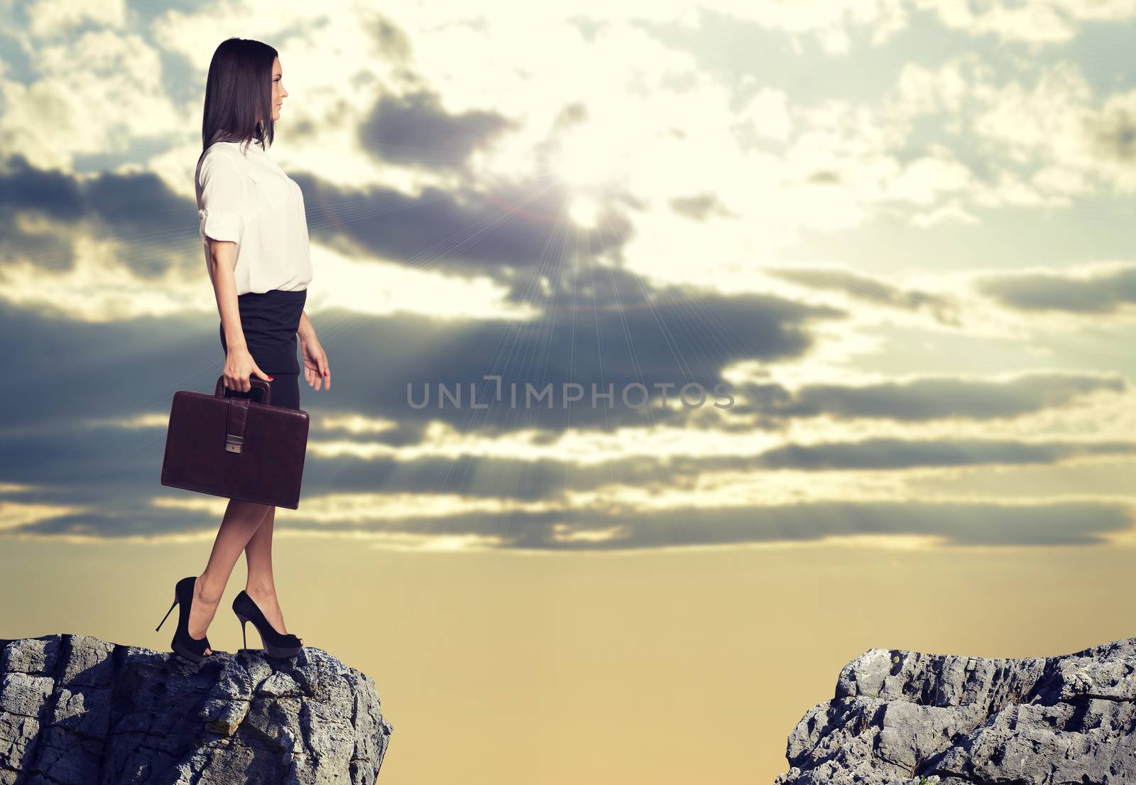 Businesswoman standing on the edge of rock gap by cherezoff