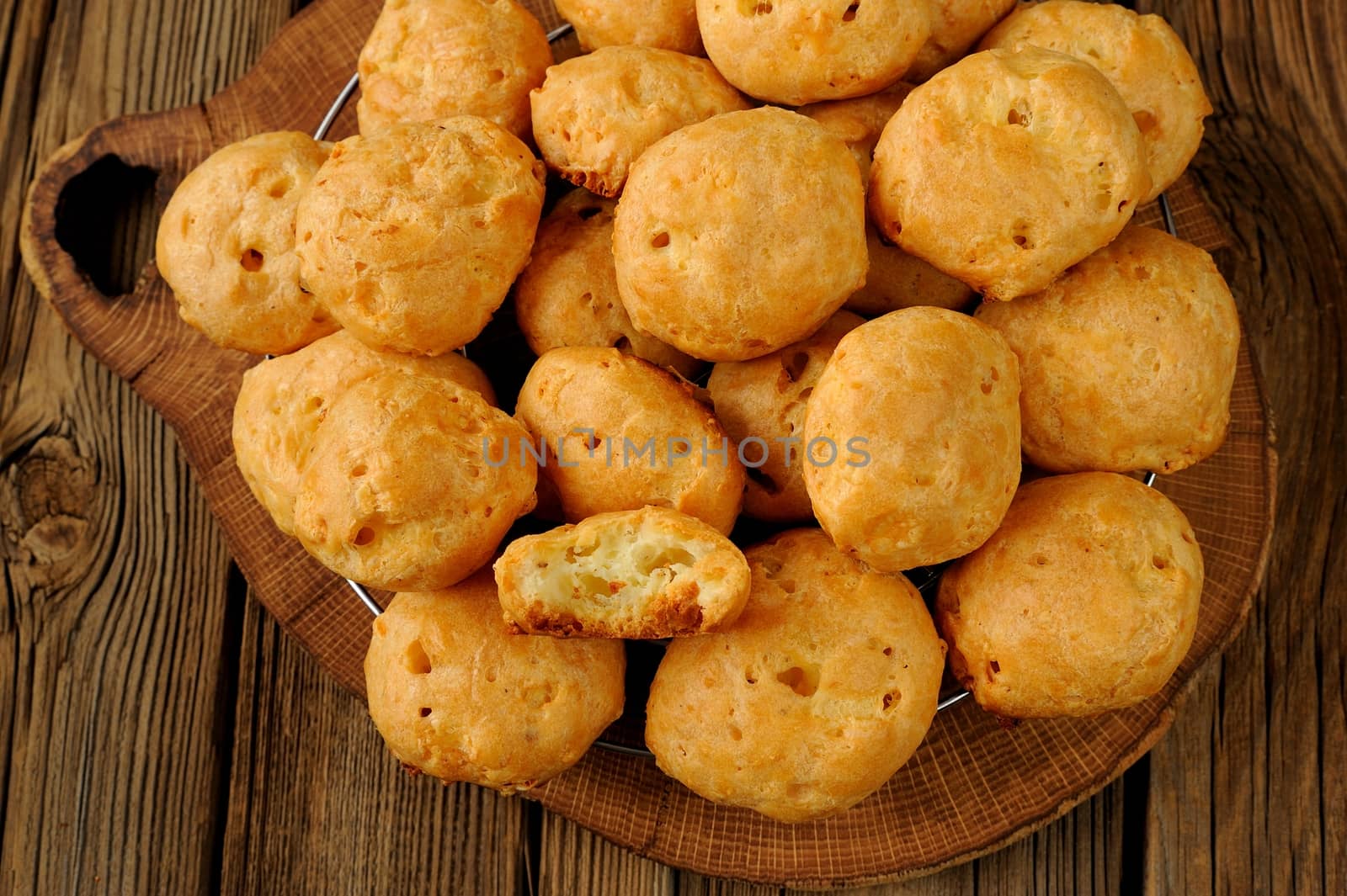 Gougeres on wood board with wooden background