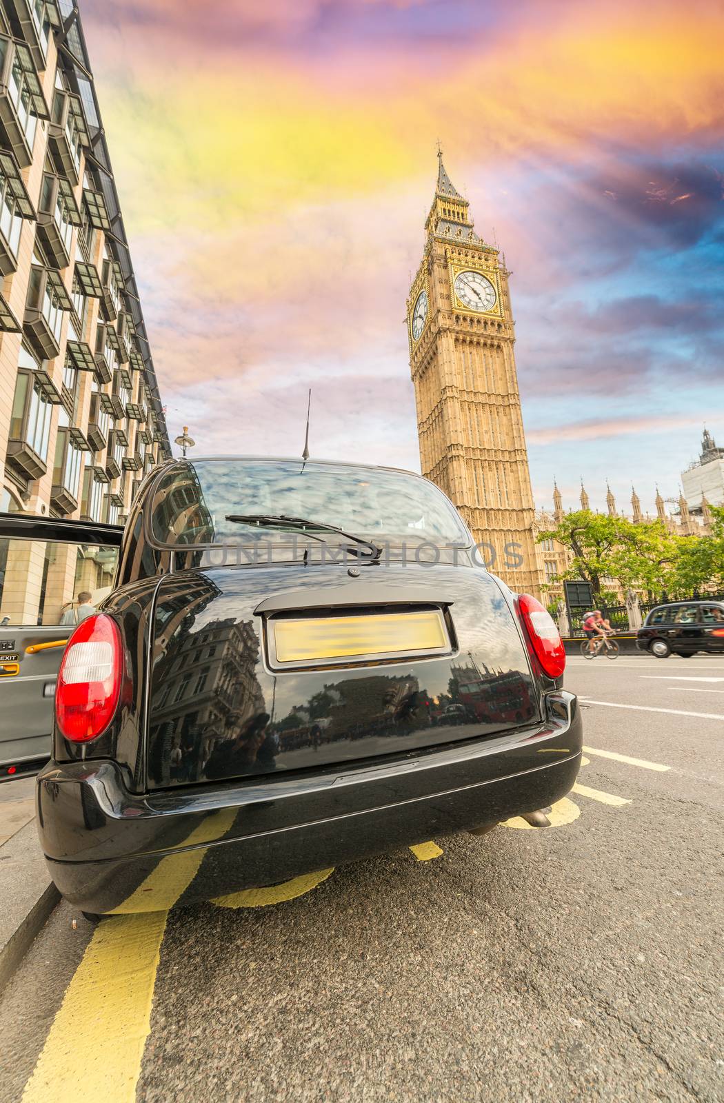 Black London cab under Big Ben tower and Westminster Palace by jovannig