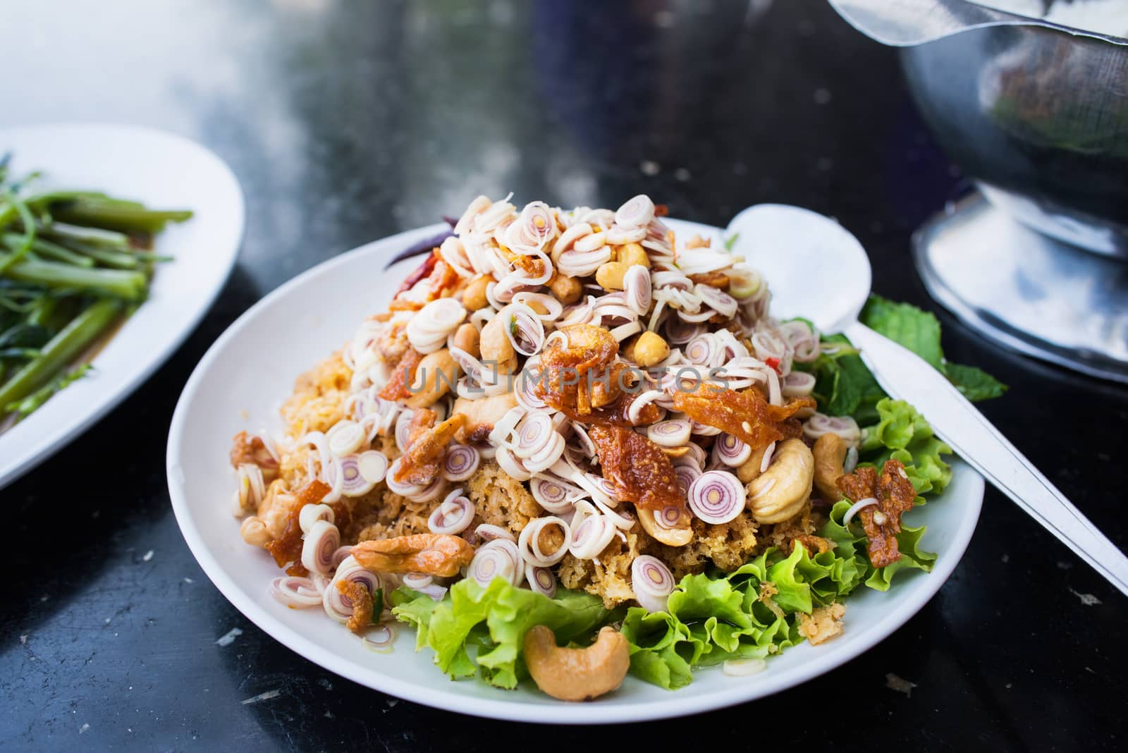 Yam pla duk foo, a spicy and sour salad with finely chopped, fried, crisp catfish, a popular course all over Thailand that exists in countless varieties. Shallow depth of field with the central part of the photo in focus.