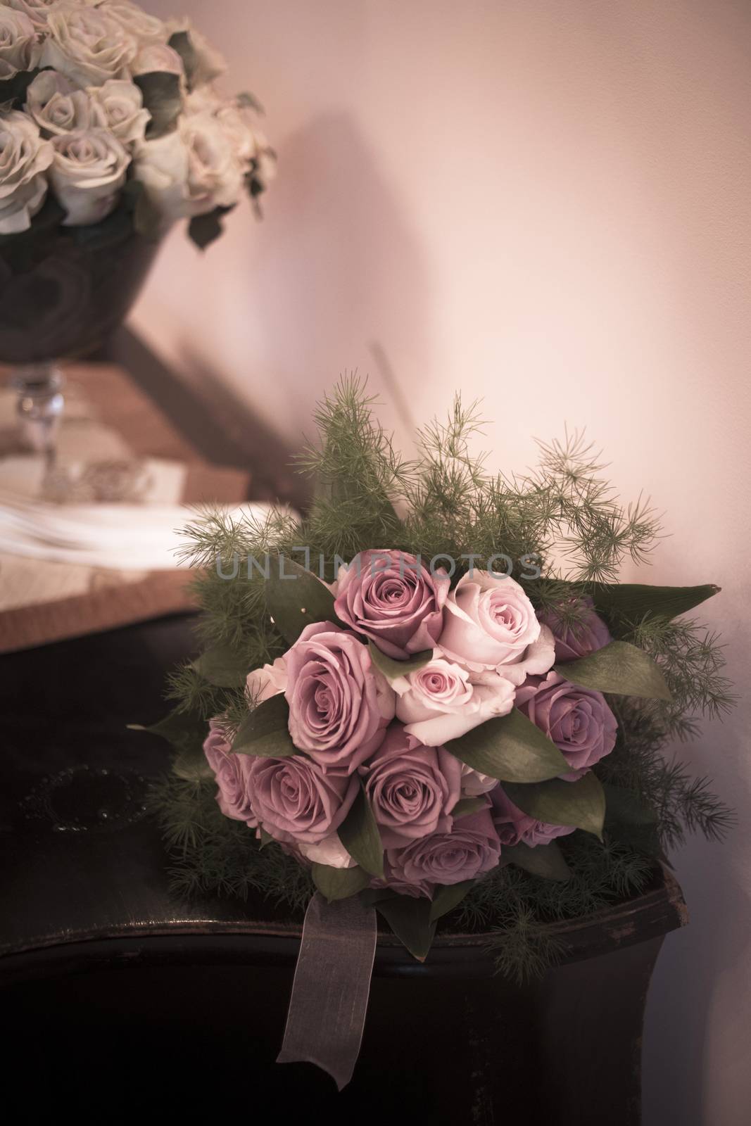 Color artistic digital rectangular vertical photo of the bride's bridal and bridesmaid's bouquets of flowers including white white and pink roses before marriage ceremony in Spain. Shallow depth of with background out of focus. 