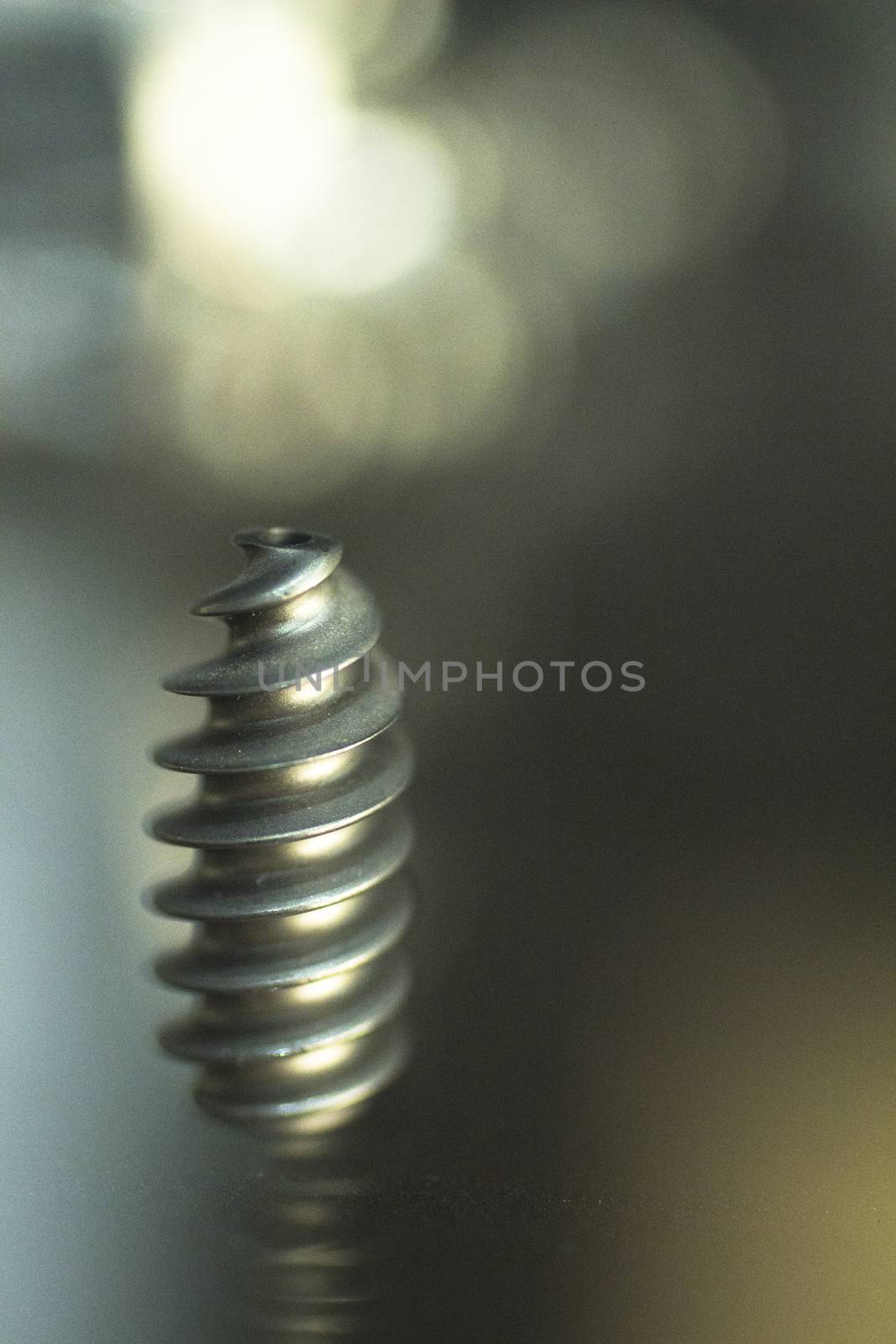 Closeup macro photo of traumatology orthopedic surgery implant metal screw set against out of focus background. 