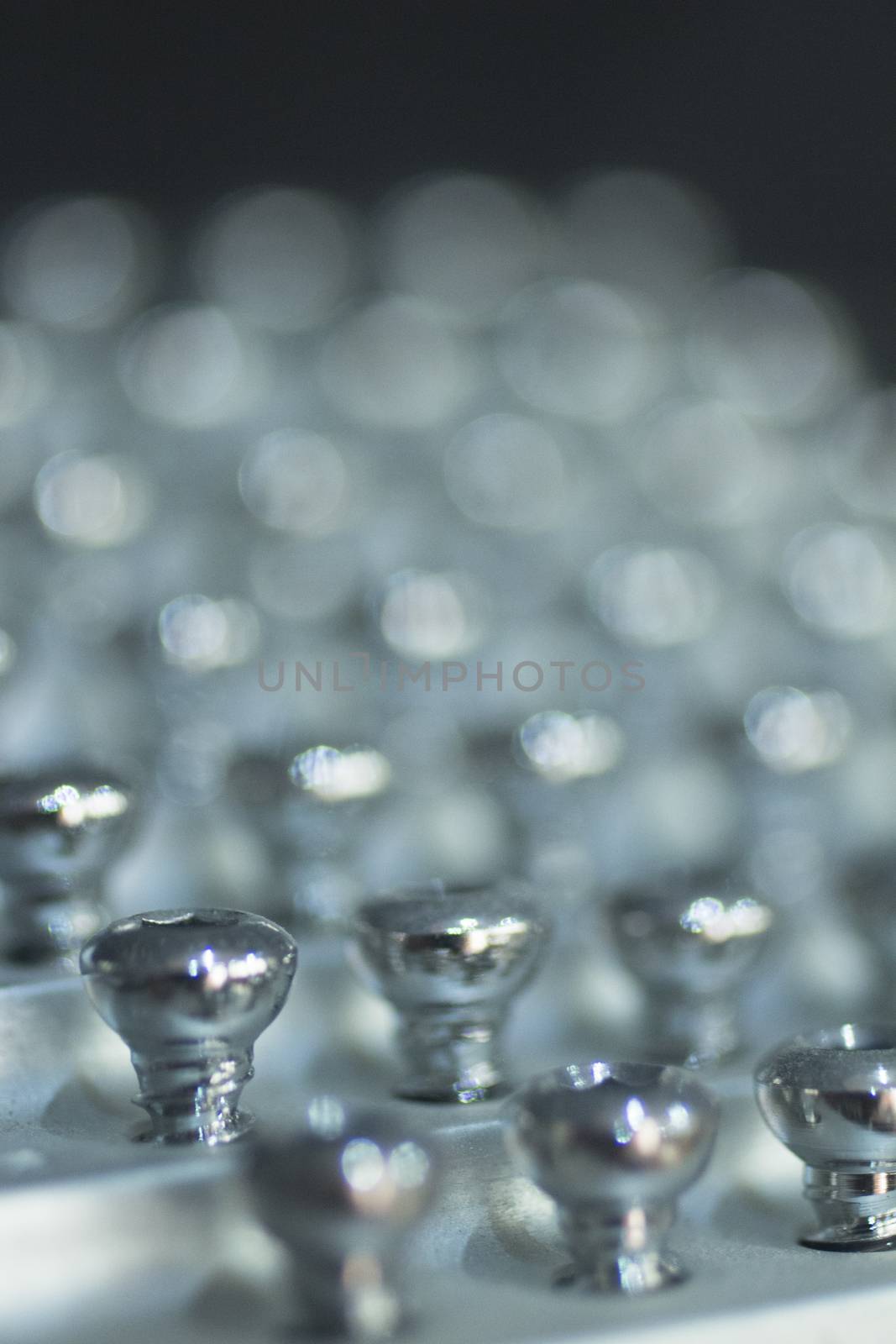 Closeup macro photograph of traumatology orthopedic surgery implant metal screws in racks ready for use by surgeon in surgery operations. 