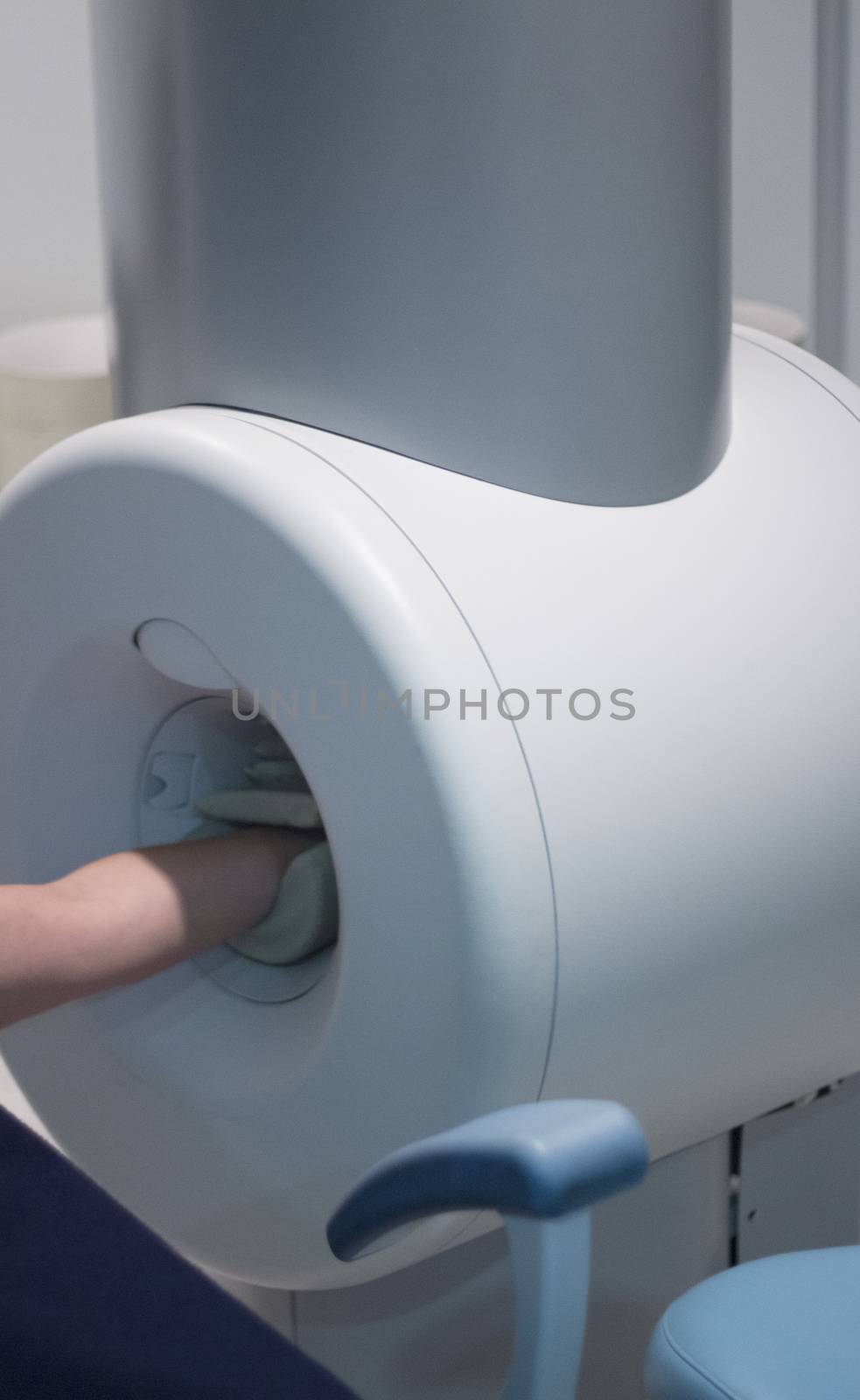 Completely open high field MRI scanner with patient lying with arm being scanned. Magnetic resonance imaging and scanning. 