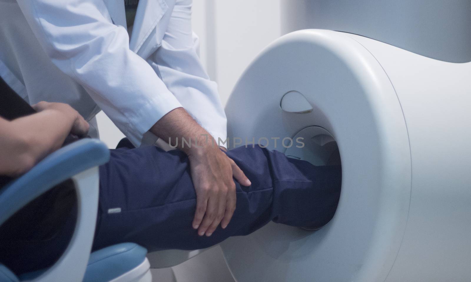 Patient and Doctor in fully open high field Magnetic Resonance Image MRI CAT Scan scanning knee and leg.