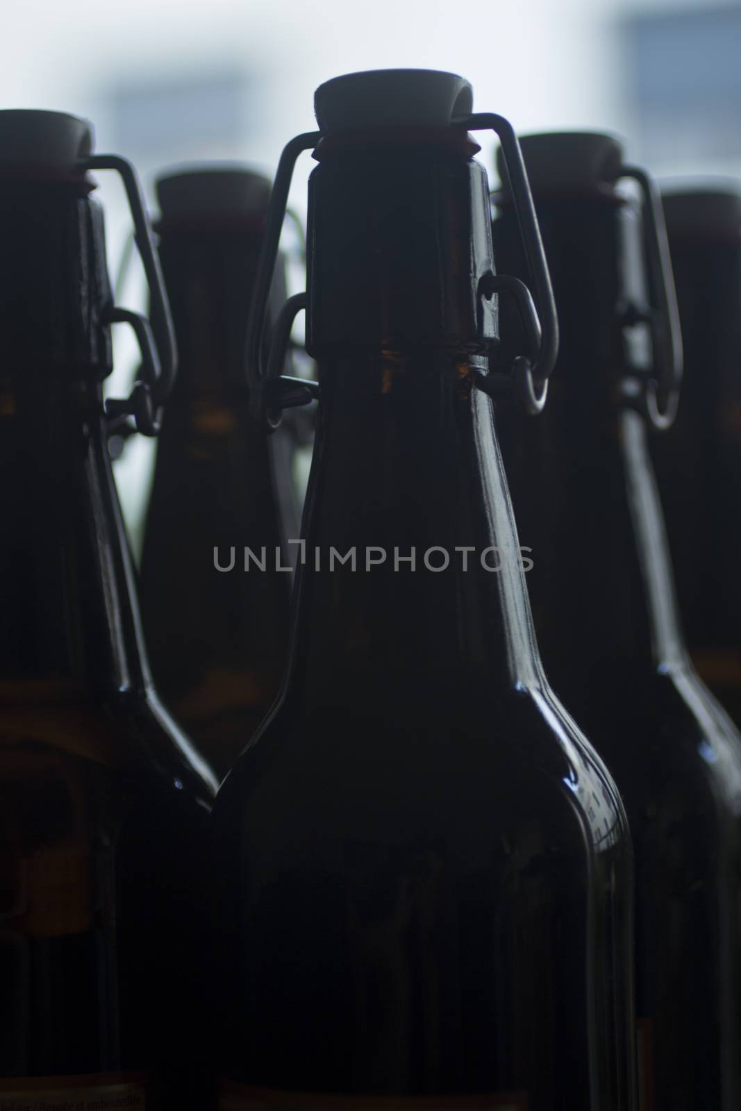 Lager beer bottle with clamp top studio isolated close-up on plain blue background color photo,
