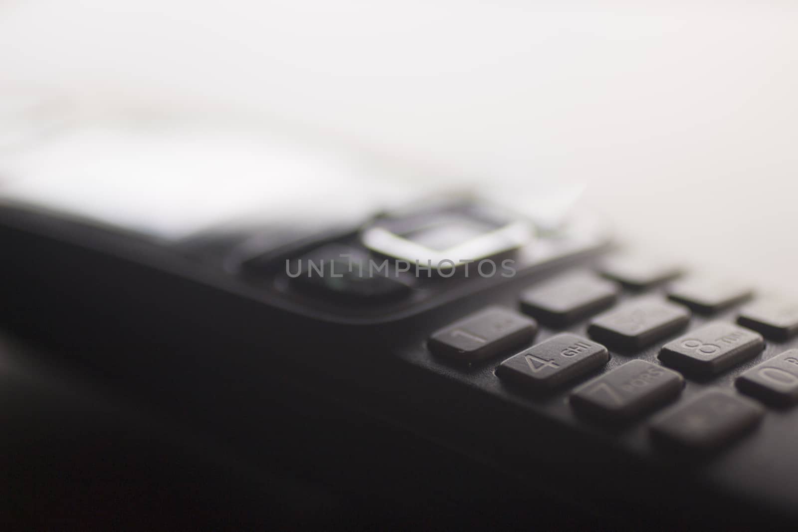 Close-up macro photo of a hands wifi free domestic home or work office fixed line telephone keypad. Artistic color digital photo with shallow depth of focus.