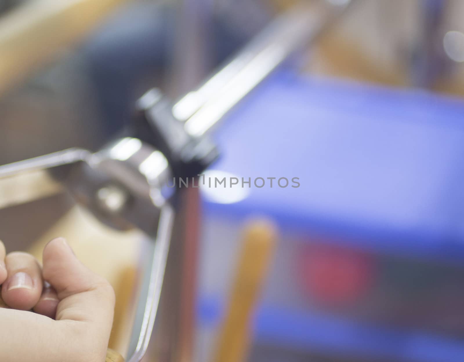 Close-up photo of hand of a male patient in physiotherapy rehabilitation treatment from orthopedic surgery in a hospital clinic physiotherapy room turning a wheel to build strength in his wrist and forearm muscles.