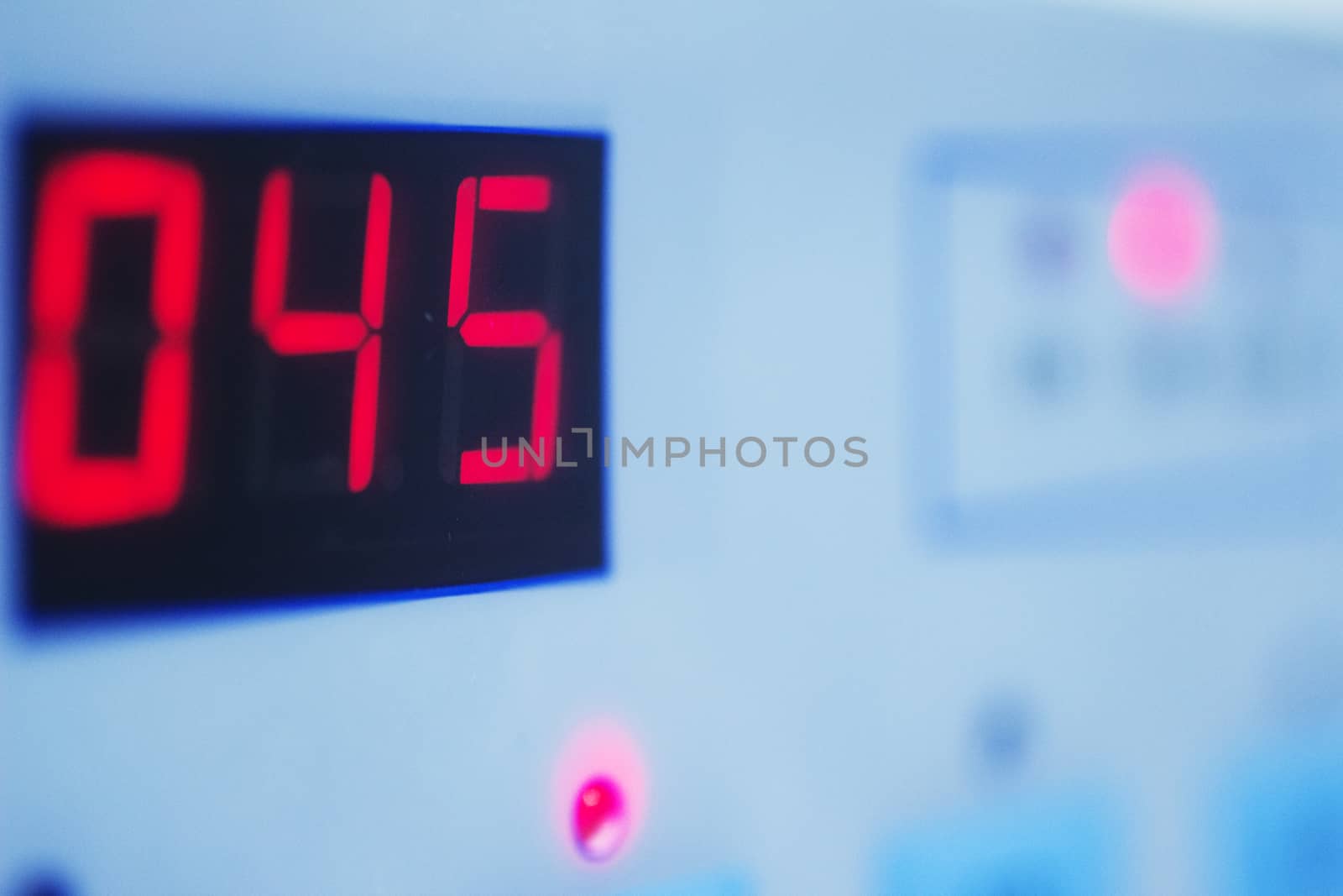 Close-up macro photo of built a medical laboratory machine used to prepare human growth factors for Traumatology rehabilitation digital readout showing 045 in blue tone. Artistic color digital photo with shallow depth of focus. 