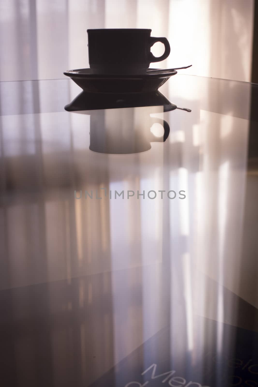 Tea or coffee cup and saucer on table silhouette by edwardolive