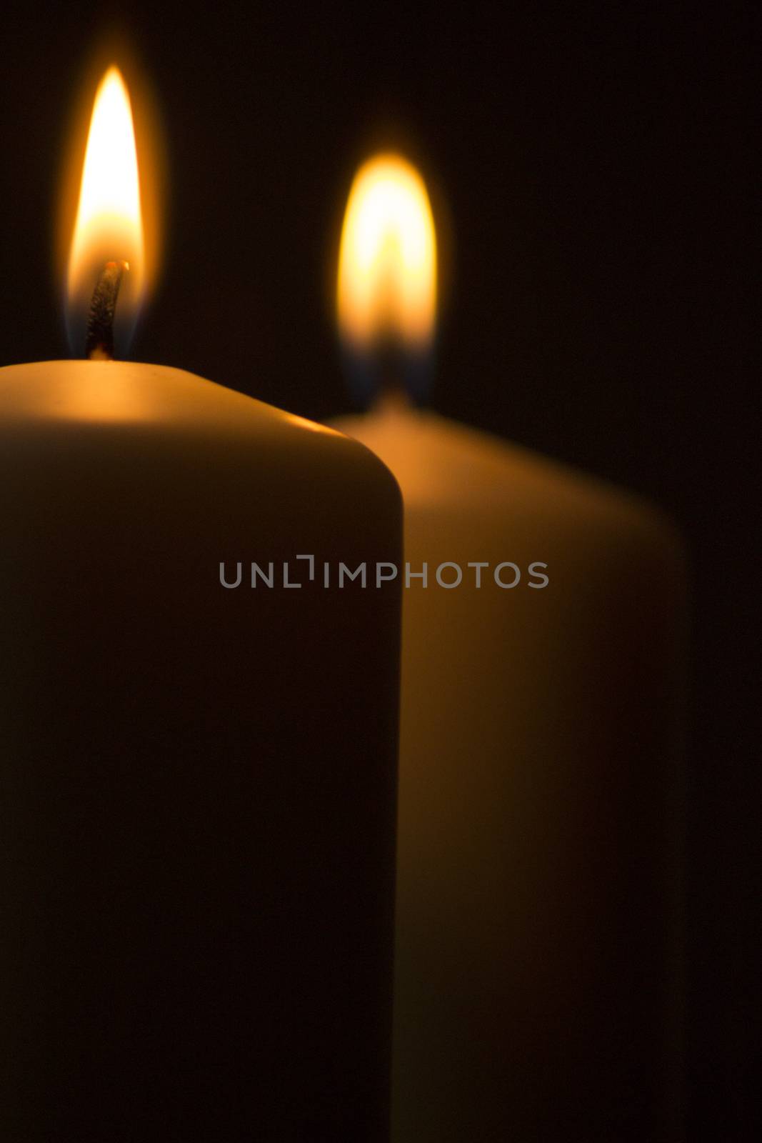 Candles lights burning close-up plain background by edwardolive
