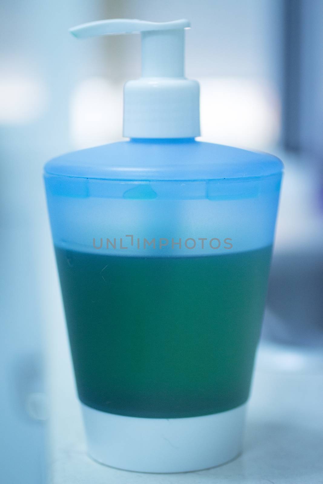 Liquid soap bottle of handwash in bathroom phtoo in blue and green.