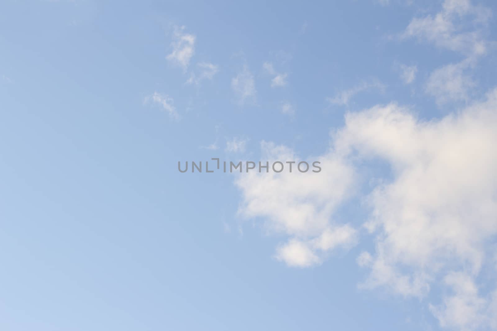 Blue bright summer sky with soft light white clouds on sunny warm day in Madrid Spain horizontal rectangular photo.