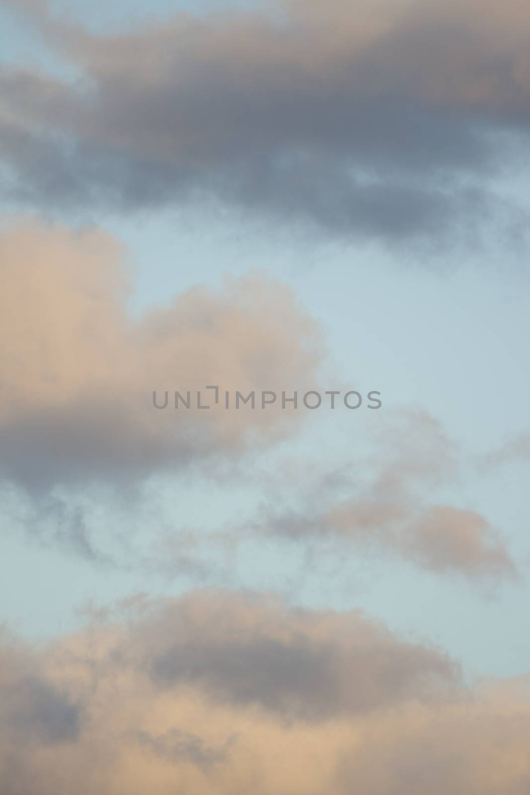 Blue bright summer sky with grey rain clouds on windy Autumn day in Madrid Spain vertical rectangular photo.