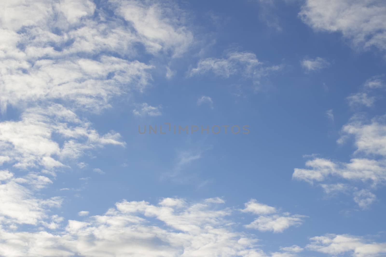 Blue sky with soft light white clouds sunny warm day  by edwardolive