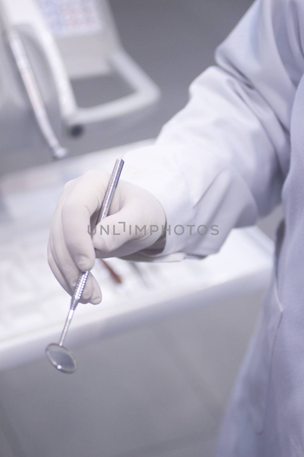 Dental instrumentation dentist drill tooth dental cleaning tool in the hand of dentist in dentists surgery clinic artistic color photo with low depth of focus.