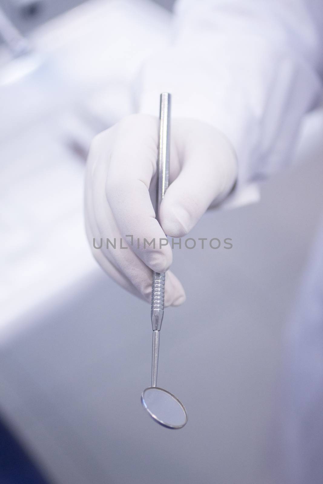 Dental instrumentation dentist drill tooth dental cleaning tool in the hand of dentist in dentists surgery clinic artistic color photo with low depth of focus.