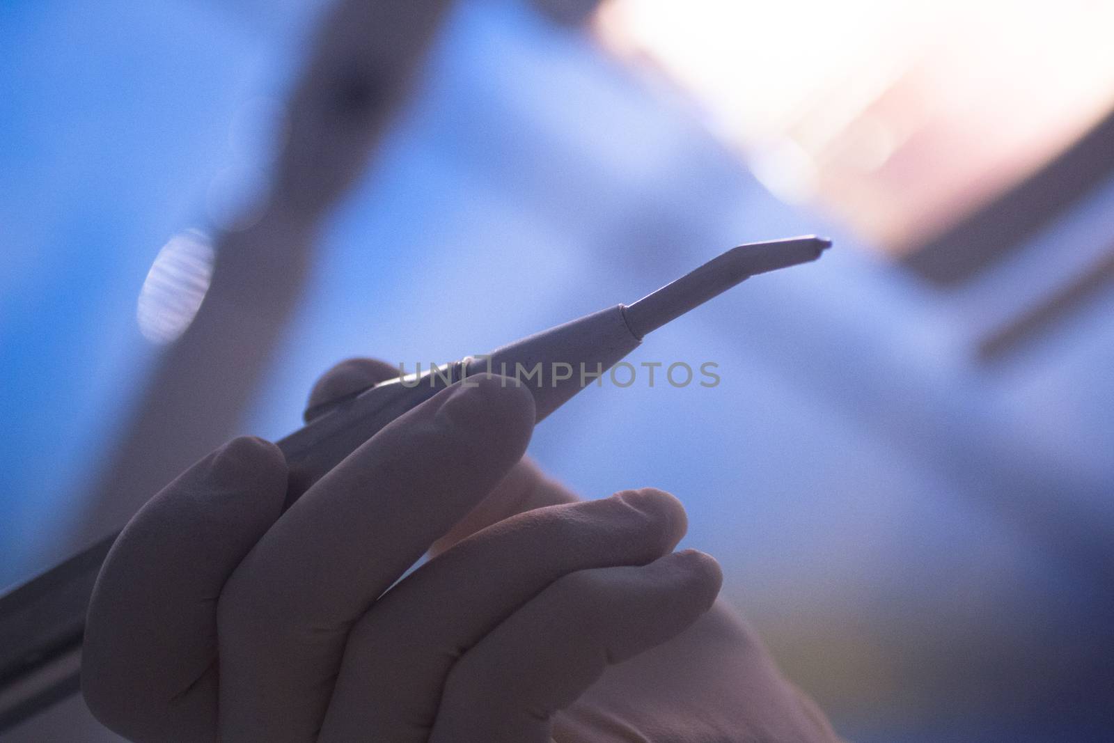 Dental instrumentation dentist drill tooth dental cleaning tool in the hand of dentist in dentists surgery clinic artistic color photo with low depth of focus.