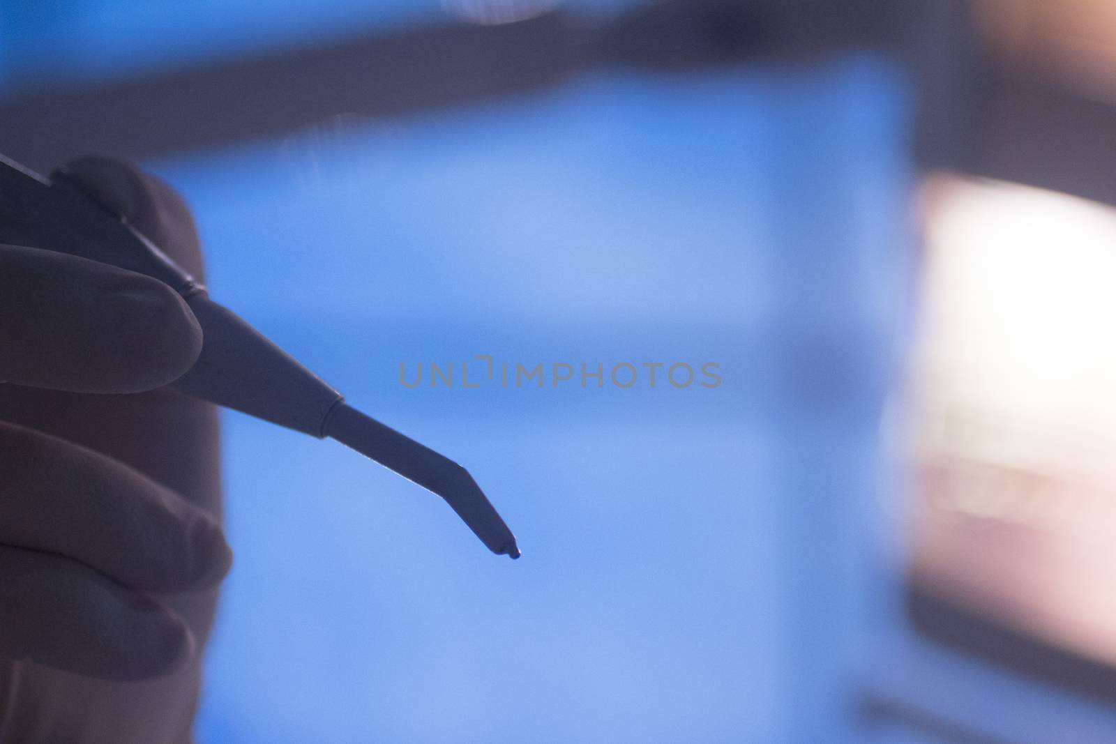 Dental instrumentation dentist drill tooth dental cleaning tool in the hand of dentist in dentists surgery clinic artistic color photo with low depth of focus.