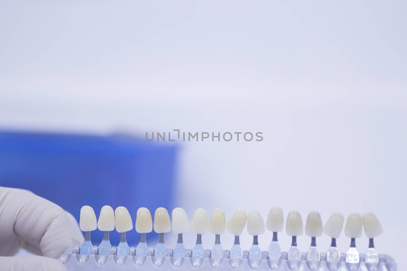 Dental nurse holding implant and crown tooth color guide by edwardolive