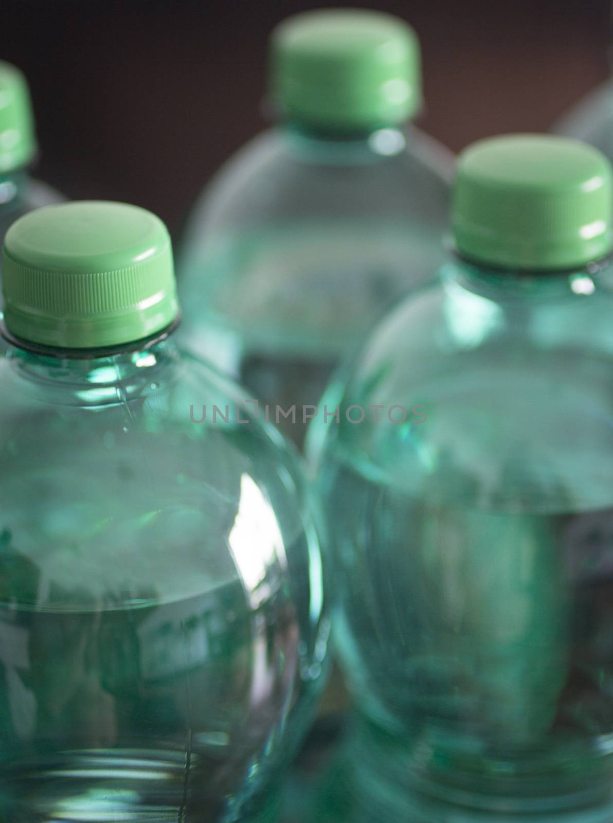 Large bottles of 1.5 litre sparkling mineral drinking water in green tone shot from above close-up color photo. 