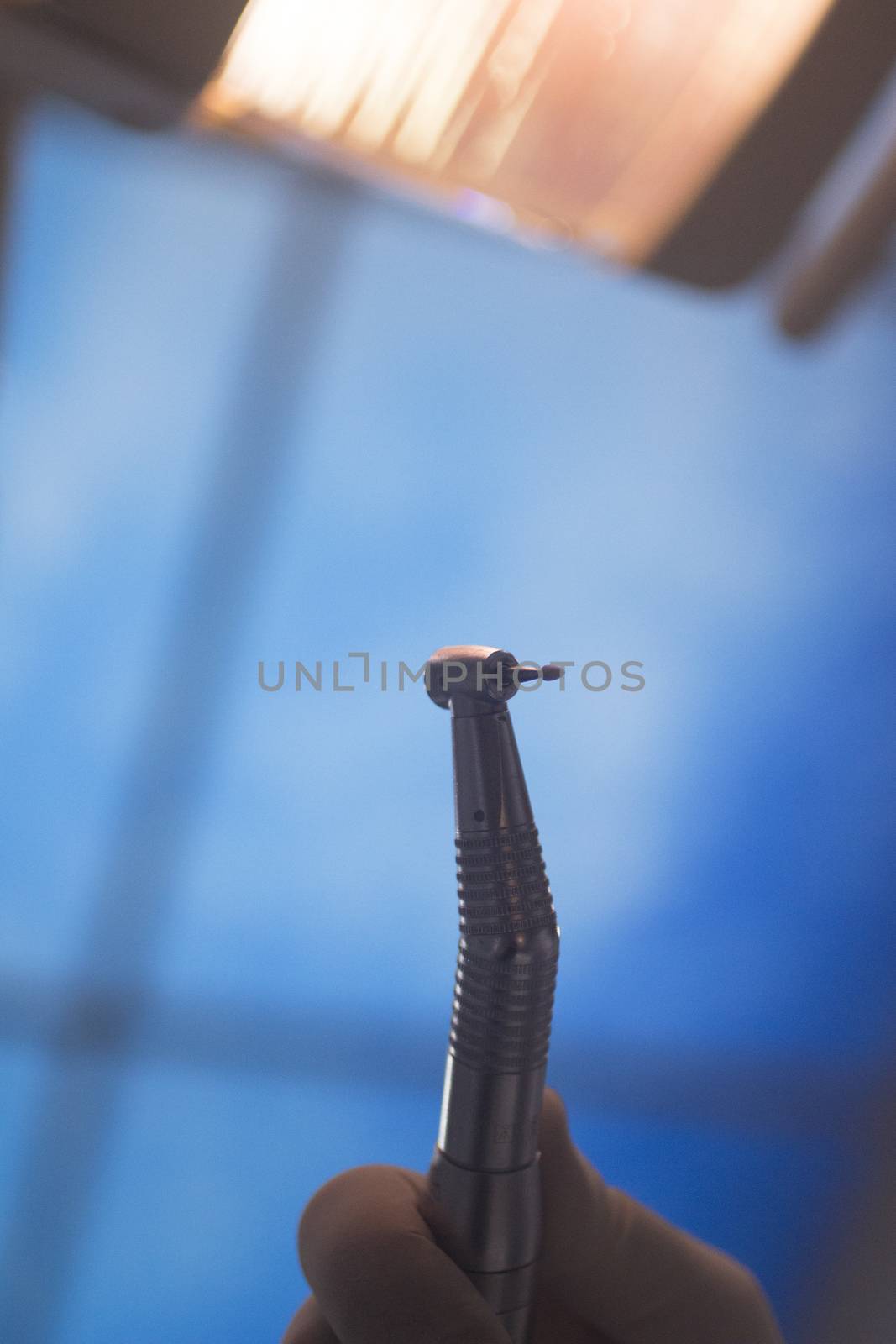 Dental instrumentation dentist drill tooth dental cleaning tool in the hand of dentist in dentists surgery clinic artistic color photo with low depth of focus.