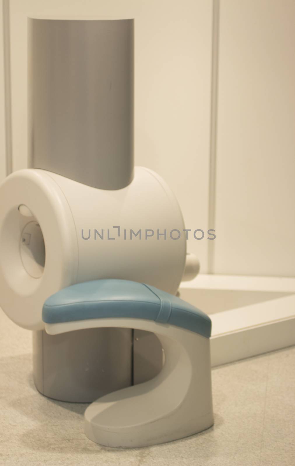 Fully Open High Field extremity scanning MRI Magnetic resonance imaging scanner for elbow, wrist, arm, thigh, calf, knee, ankle and foot scans and patient stool in the scan room of a hospital clinic.