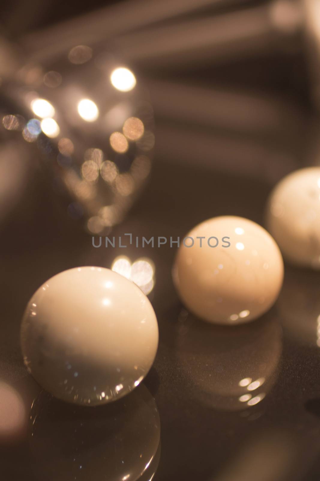 Three round traumatology and orthopedic surgery ball and socket joint implants. Still life color digital photo in brown tones with shallow depth of focus bokeh artistic effect and reflection. 
