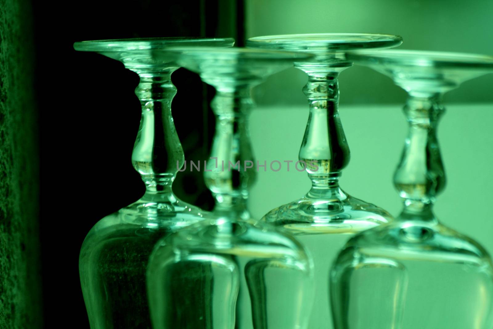 Upturned wine glasses in restaurant bar close-up  by edwardolive