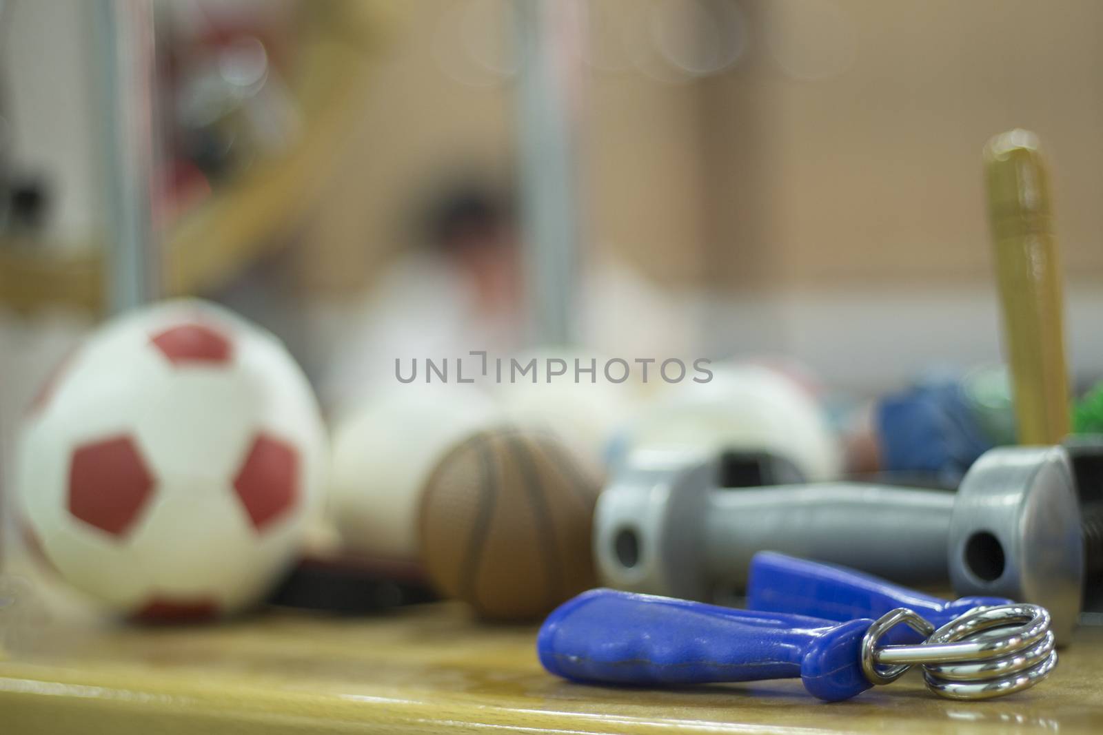 Hand exerciser, mini football, mini basketball, dumbell weight and other physiotherapy rehabilitation treatment equipment for pateint recovery from orthopedic surgery in a hospital clinic physiotherapy room on a wooden table.