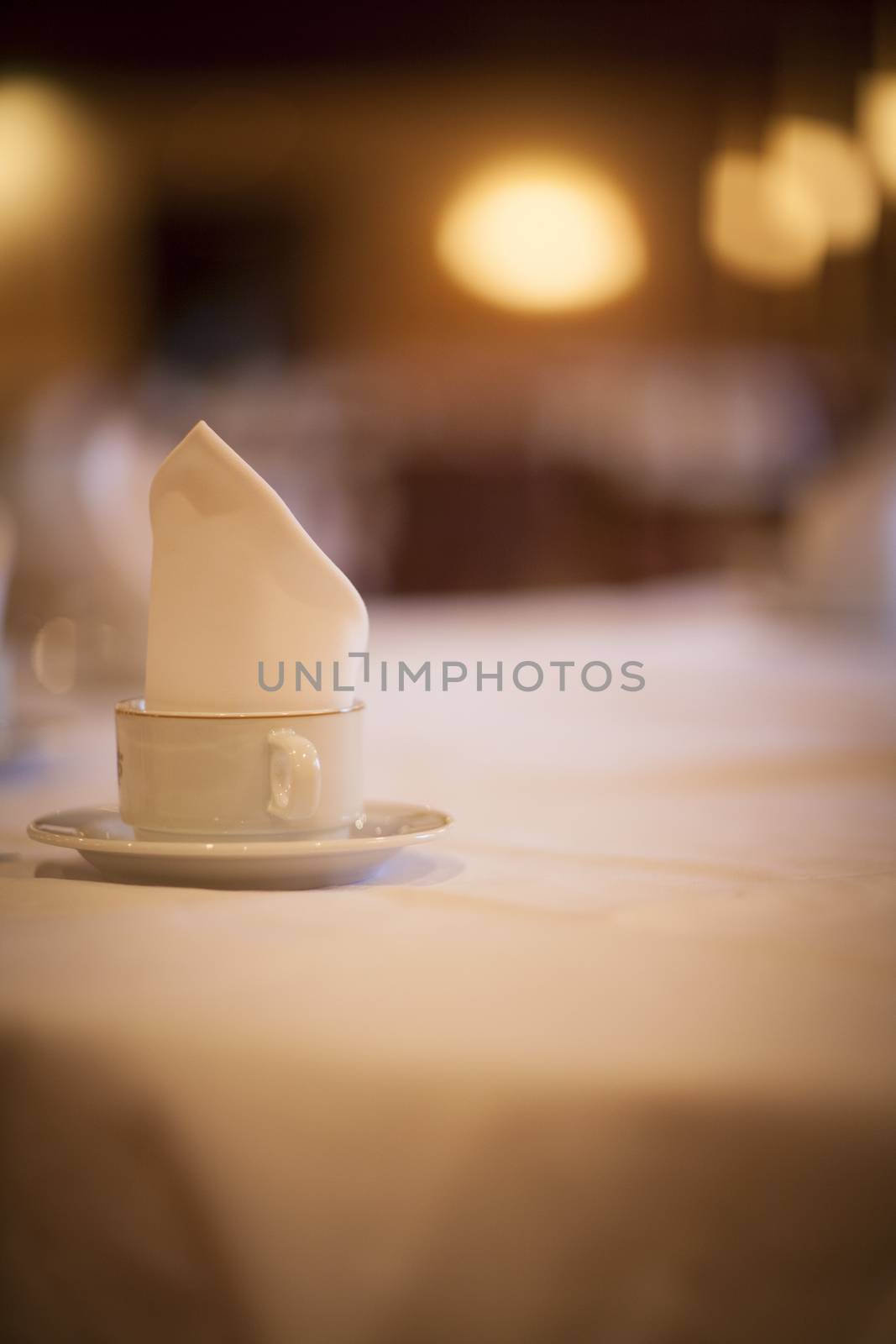 Coffee tea cup on wedding marriage reception banquet table with saucer and serviette close-up photo with defocused background. 