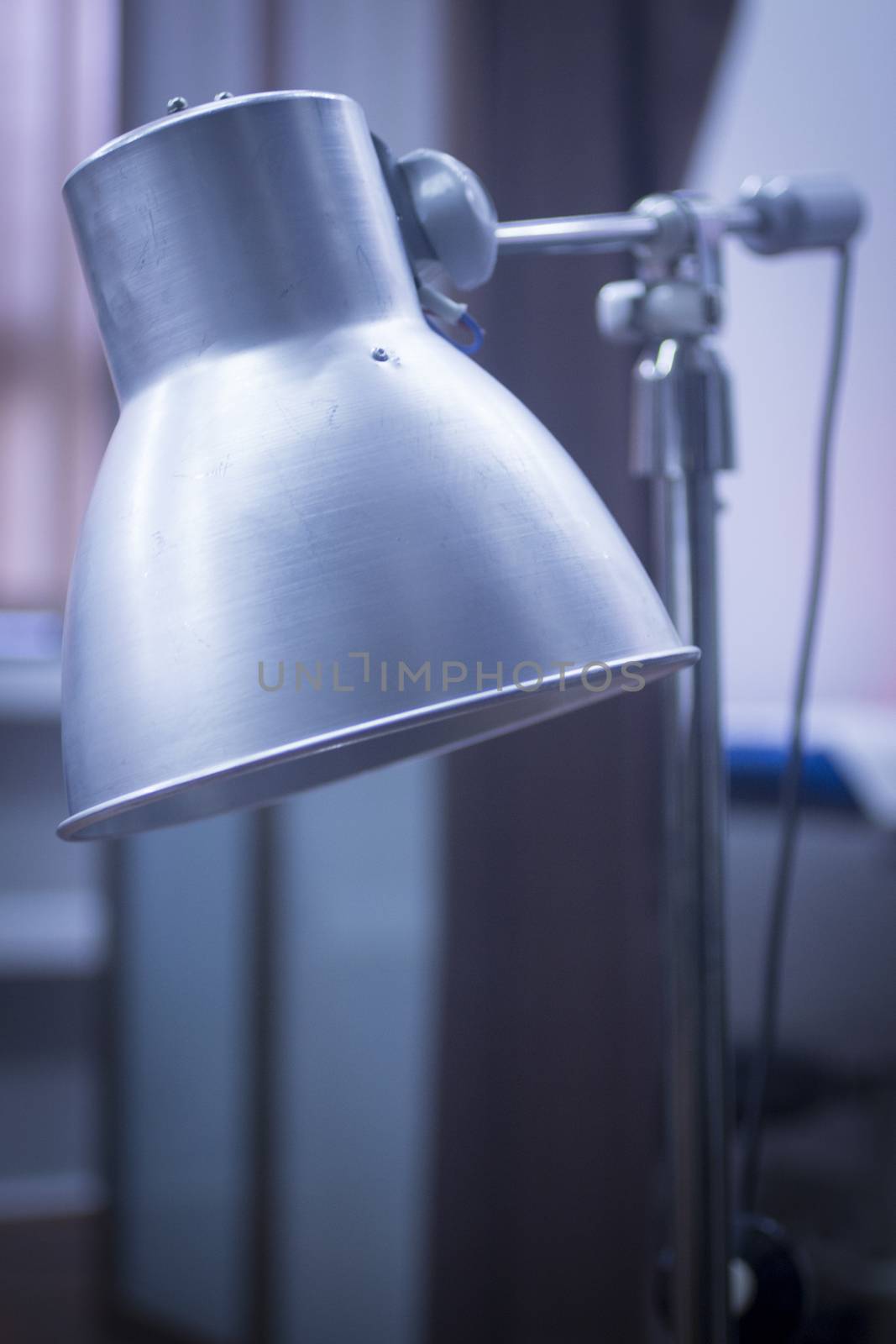 Physiotherapy heat medical rehabilitation lamp in hospital clinic in artistic tones. 